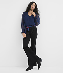 A woman wearing a navy blue blouse and black flared trousers stands against a plain white background. carousel Product Image 2