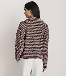 A woman wearing a patterned maroon and white jacket and white pants stands against a plain light-colored background. carousel Product Image 3