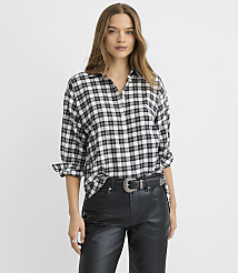 A woman wearing a black and white plaid shirt and black leather pants stands against a plain white background. carousel Product Image 1