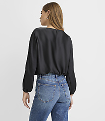 A woman wearing a black satin blouse and blue jeans stands with her back to the camera against a plain white background. carousel Product Image 3