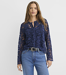 A woman wearing a navy blue lace blouse and blue jeans stands against a plain white background. carousel Product Image 1