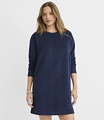 A woman wearing a navy blue cable-knit sweater dress stands against a plain white background. carousel Product Image 1