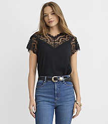 A woman wearing a black lace-trimmed top and blue jeans stands against a plain white background. carousel Product Image 2