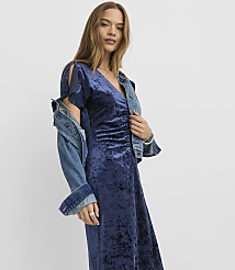 A woman wearing a navy blue velvet dress and a denim jacket stands against a plain white background. carousel Product Image 2