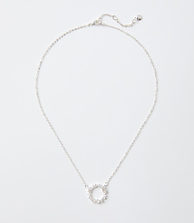 A silver necklace with a circular sparkling pendant rests on a plain white background. carousel Product Image 1