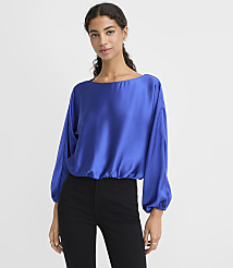 A woman wearing a royal blue satin blouse and black pants stands against a plain white background. carousel Product Image 1