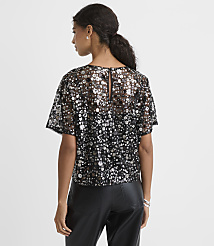 A woman wearing a sequined black top and leather pants stands against a plain white background. carousel Product Image 3