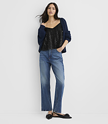 A woman wearing a black sequined top, a navy blue cardigan, and blue jeans stands against a plain white background. carousel Product Image 2