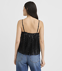 A woman wearing a black sequined top and blue jeans stands with her back to the camera against a plain white background. carousel Product Image 3