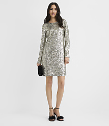 A woman wearing a long-sleeved silver sequin dress and black fluffy heels stands against a plain white background. carousel Product Image 2