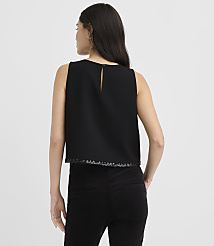 A woman wearing a black sleeveless top and black pants stands with her back to the camera against a plain light gray background. carousel Product Image 3