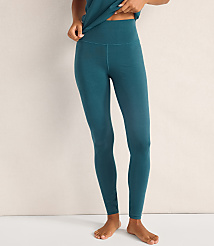 A person wearing teal leggings and a matching top stands barefoot against a plain, light-colored wall. carousel Product Image 2