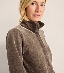 A blonde woman wearing a brown quarter-zip pullover stands against a plain, light-colored background. carousel Product Image 3
