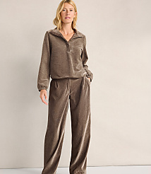 A woman wearing a brown velvet lounge set stands against a plain, light-colored wall. carousel Product Image 1
