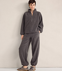 A person wearing a charcoal grey fleece pullover and matching pants stands against a plain, light-colored wall. carousel Product Image 2