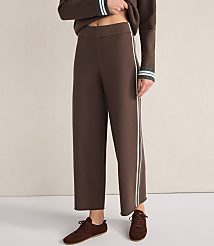 A person wears brown wide-leg trousers with white side stripes and matching brown shoes against a plain, light-colored background. carousel Product Image 2