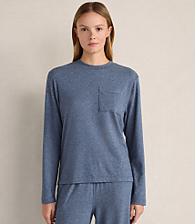 A woman wearing a blue long-sleeved shirt and matching pants stands against a plain, light-colored wall. carousel Product Image 1