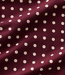 Small white polka dots are scattered across a draped, deep burgundy fabric. carousel Product Image 4