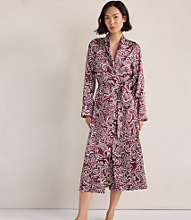 A woman wearing a maroon and white paisley print robe stands against a plain, neutral-colored wall. carousel Product Image 1