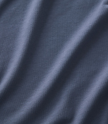 Soft, draped folds of blue-grey fabric fill the foreground and extend into the background. carousel Product Image 3