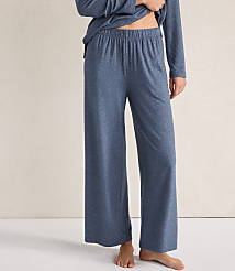 A person wears blue wide-leg lounge pants and a matching top against a plain, light-colored wall. carousel Product Image 2