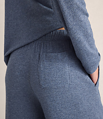 A person wears a blue long-sleeved top and matching pants with a back pocket against a plain, light-colored background. carousel Product Image 3