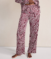 A person wears maroon and white paisley print pajama pants against a plain, light-colored wall. carousel Product Image 2