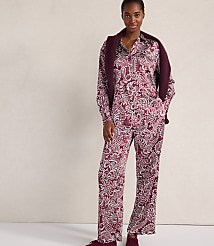 A woman wearing a maroon and white paisley print pajama set with a matching cardigan draped over her shoulders stands against a plain, light-colored wall. carousel Product Image 1