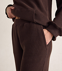 A person wears a brown waffle-knit lounge set against a plain, light-colored background. carousel Product Image 3