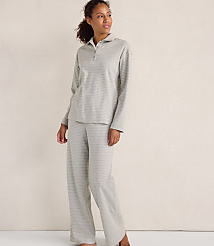 A woman wearing grey striped pajamas stands against a plain, light-colored wall. carousel Product Image 1