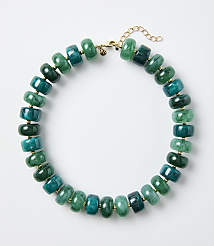 A necklace of green and teal stone beads rests on a plain white background. carousel Product Image 1