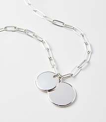 A silver chain necklace with two circular pendants rests on a plain white background. carousel Product Image 2