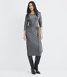 A woman wearing a shimmering silver midi dress and black knee-high boots stands against a plain white background. carousel Product Image 1