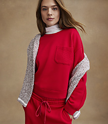 A woman wearing a red sweatshirt and matching pants with a grey cardigan draped over her shoulders stands against a plain tan background. carousel Product Image 4