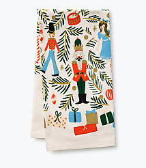Nutcrackers, a doll, and wrapped gifts are scattered across a white fabric background adorned with green pine branches and gold ornaments. carousel Product Image 1