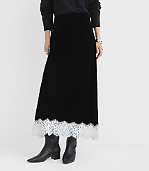 A person wearing a black velvet maxi skirt with a white lace hem and black boots stands against a plain white background. carousel Product Image 2
