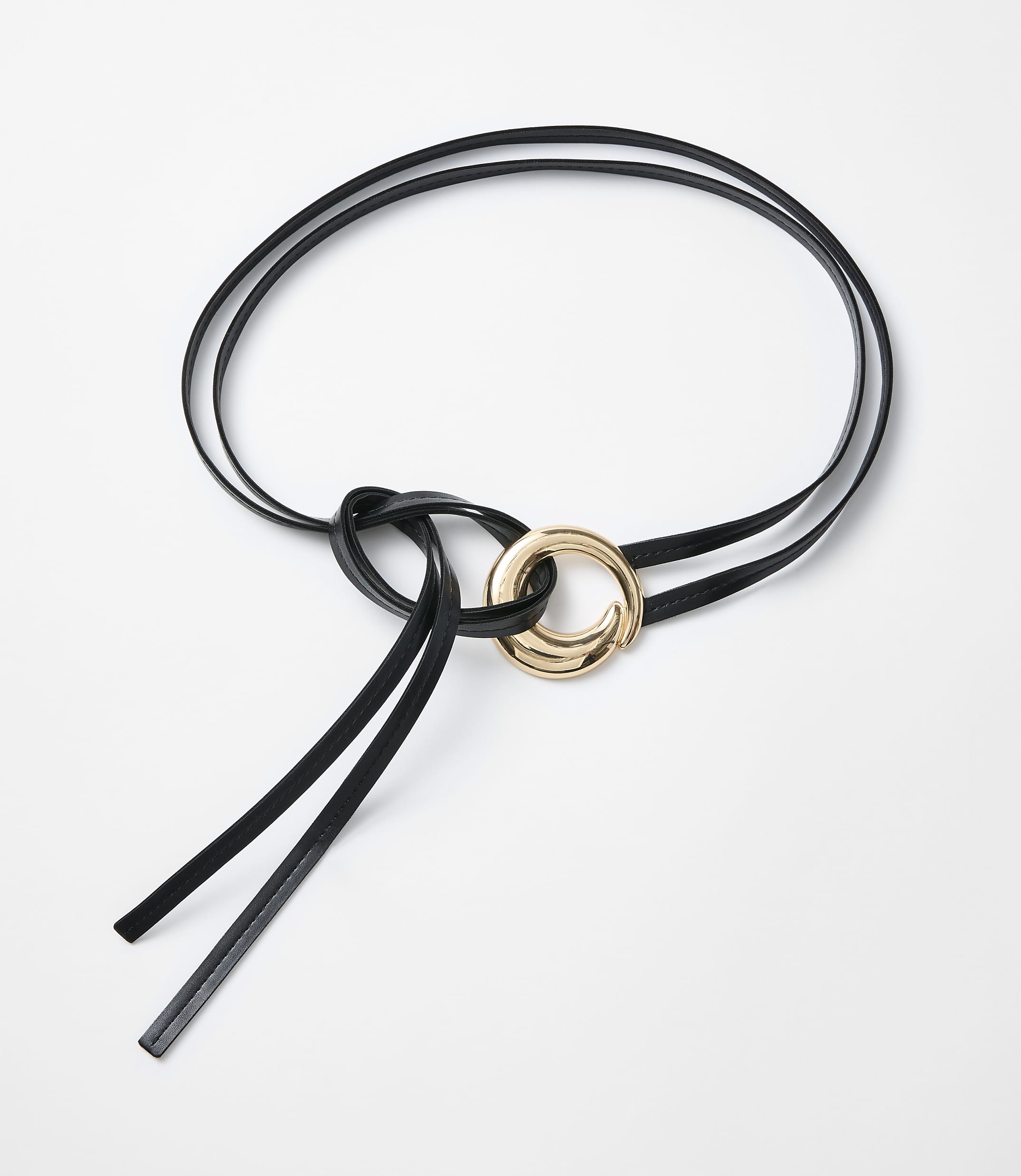 A black leather belt with a gold ring is laid out on a white background.