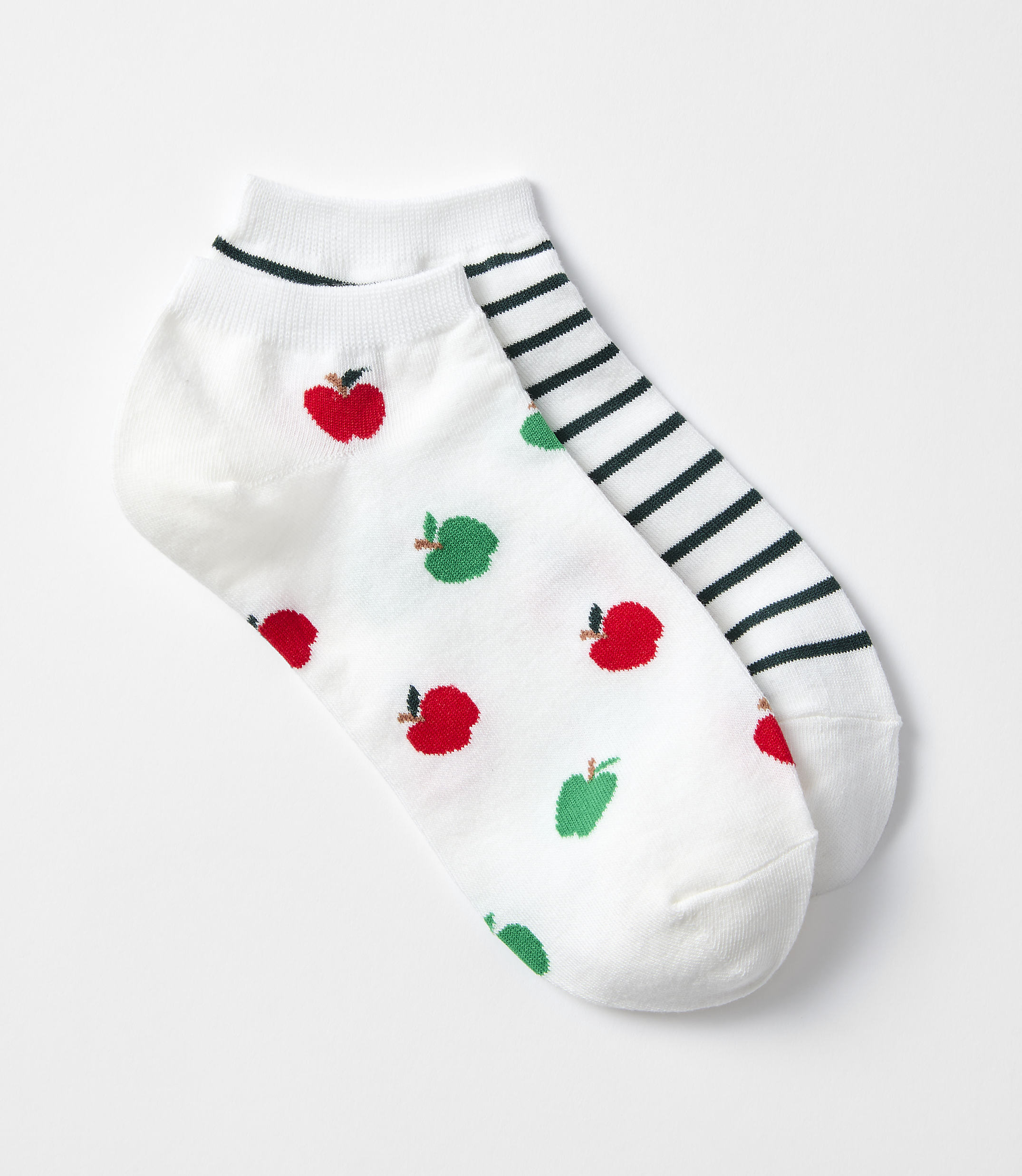 A pair of white ankle socks, one adorned with red apples and green pears, the other with black and white stripes, rests on a plain white background.