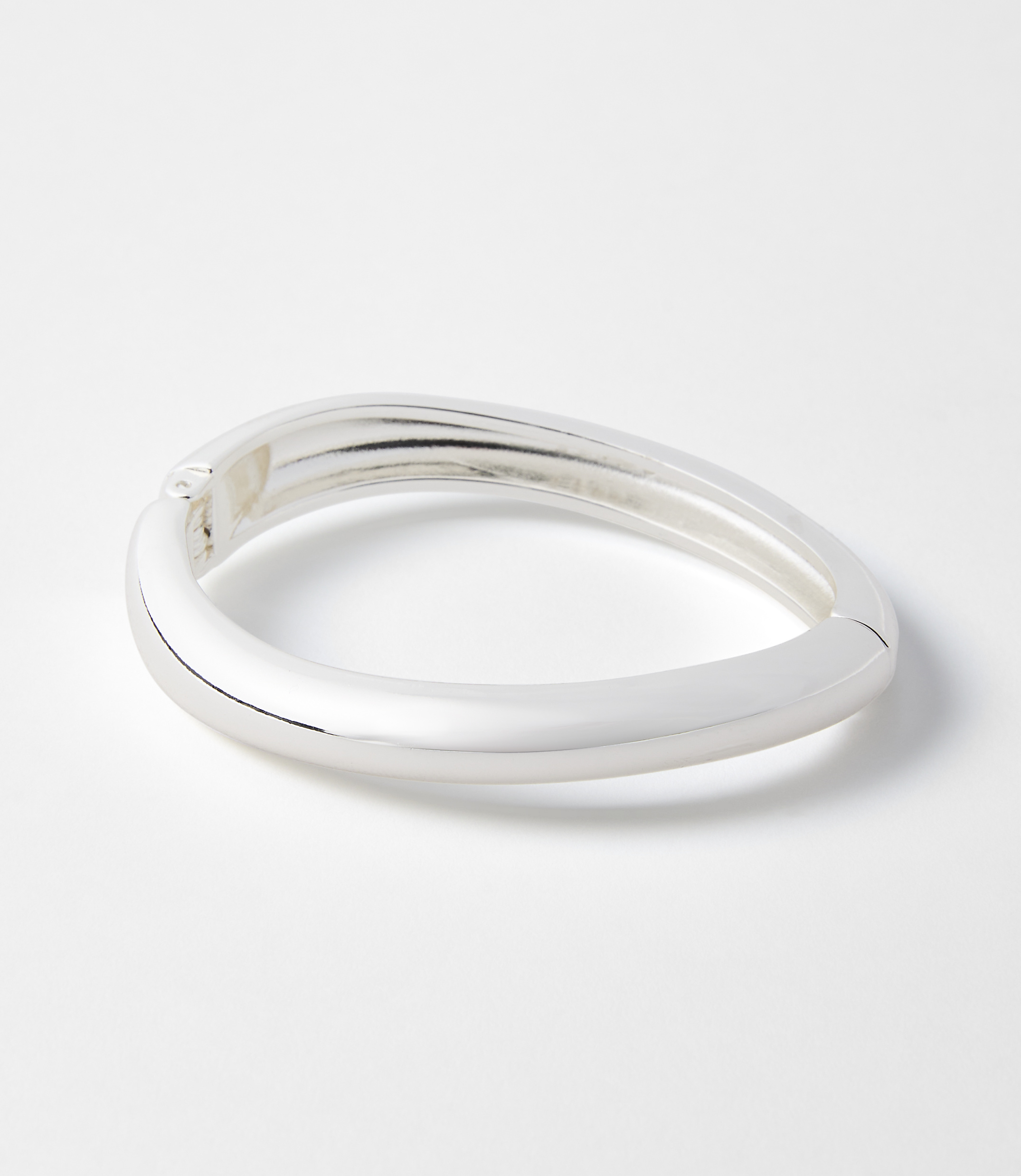 A sleek, silver bangle rests on a plain white background.
