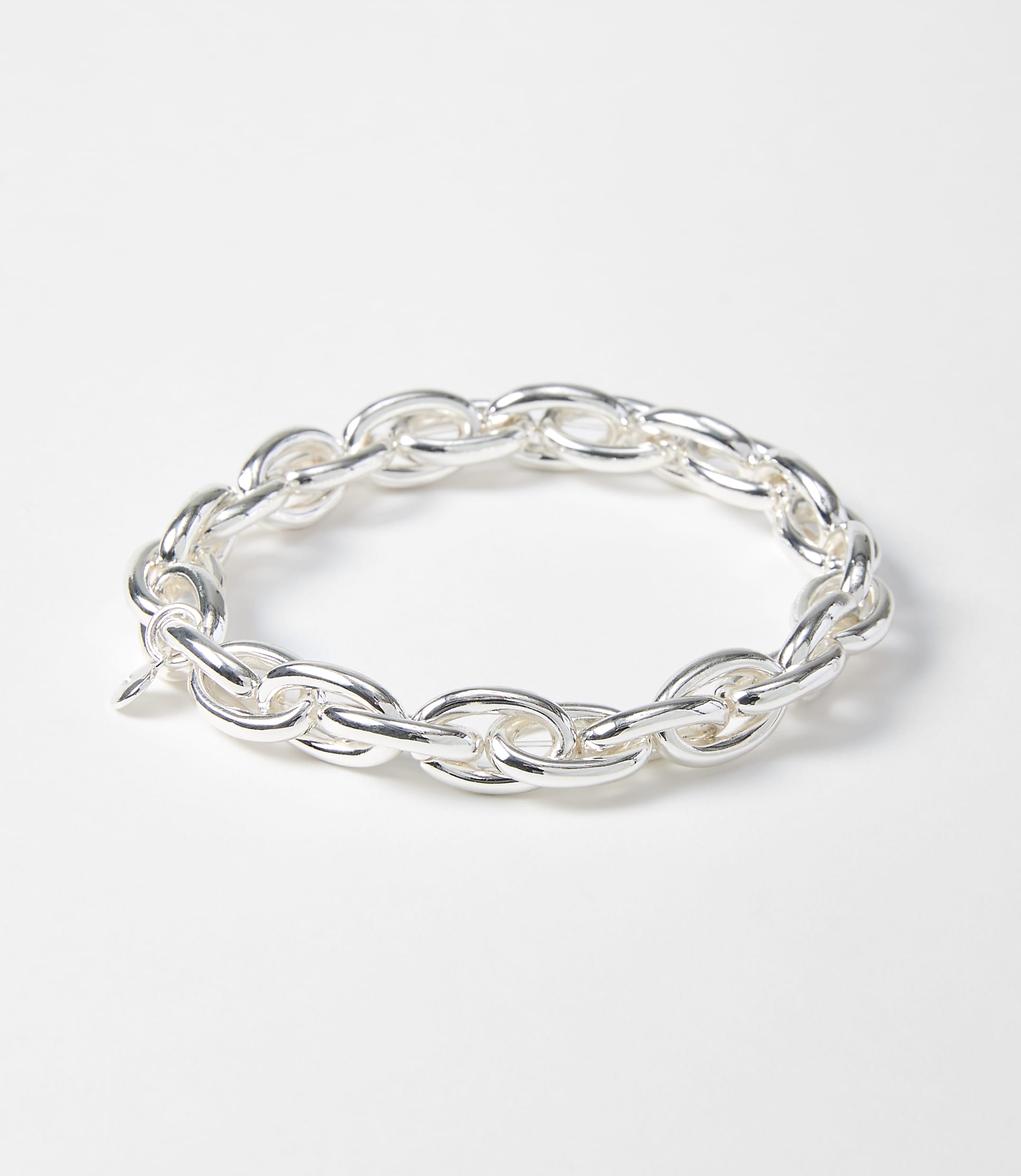 A silver chain bracelet with oval links rests on a plain white background.