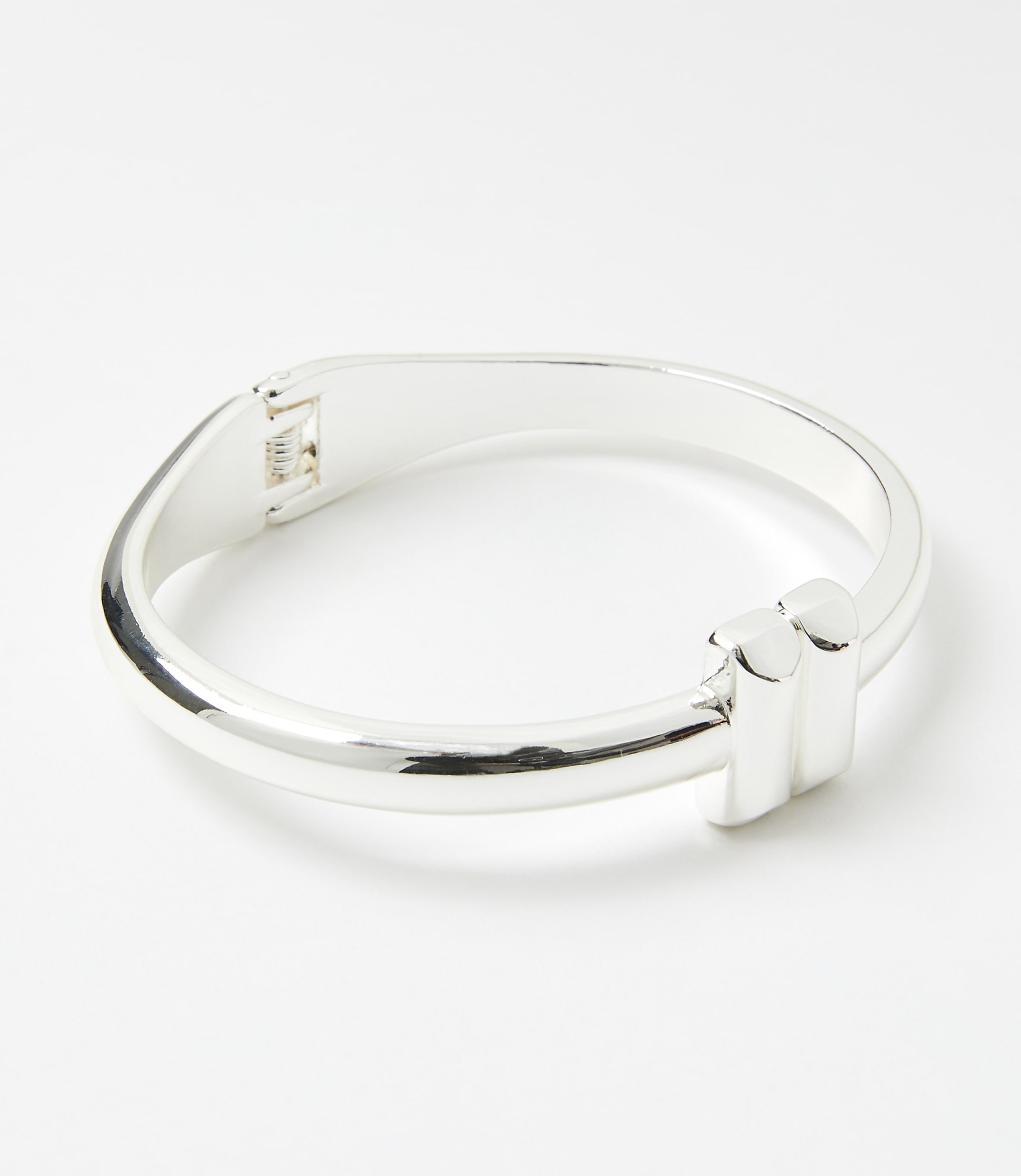 A silver bracelet with a modern design sits on a plain white background.