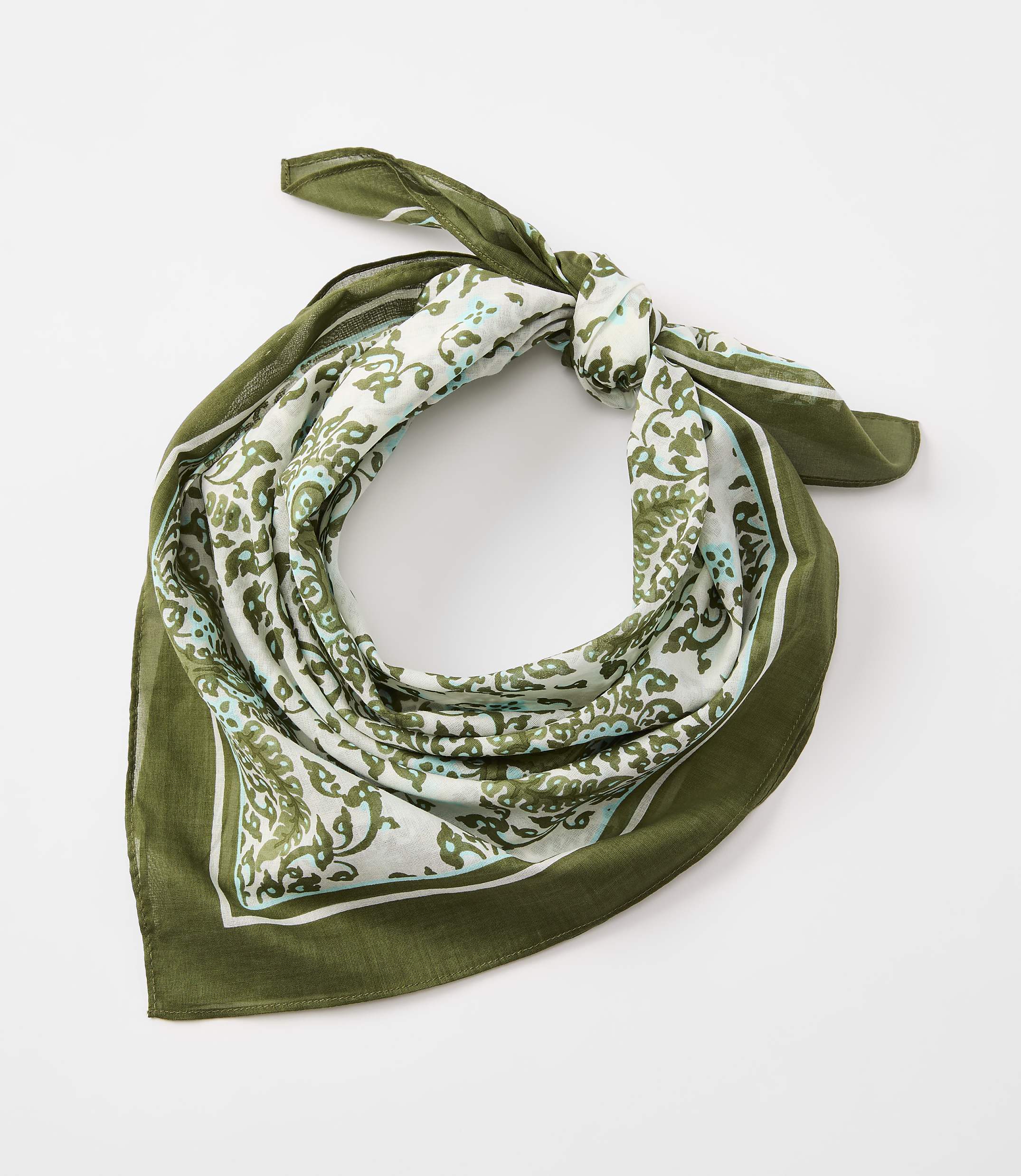 A green bandana with a white and green paisley pattern is tied in a knot against a plain white background.