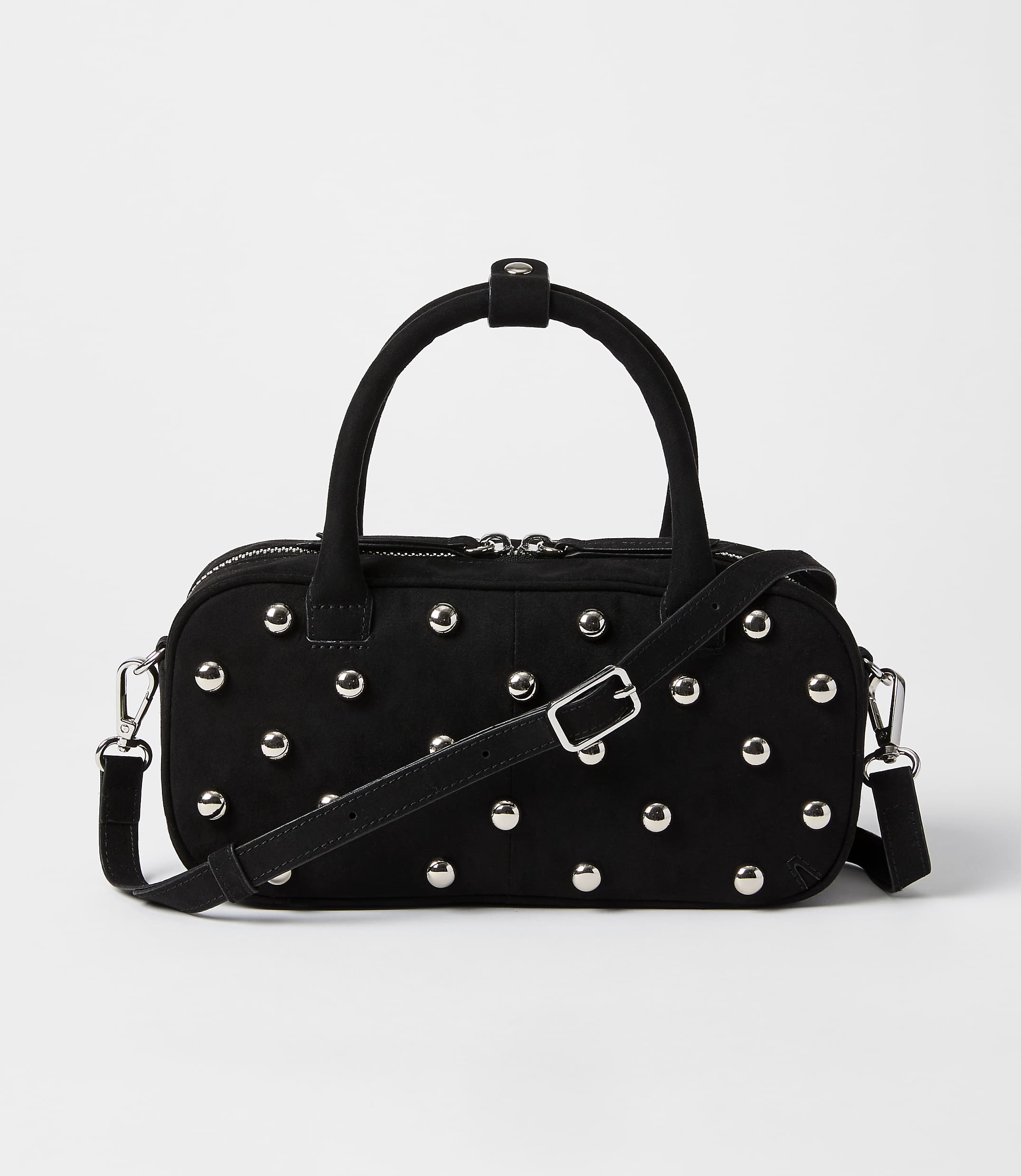A black studded duffel bag with a crossbody strap rests on a plain white background.