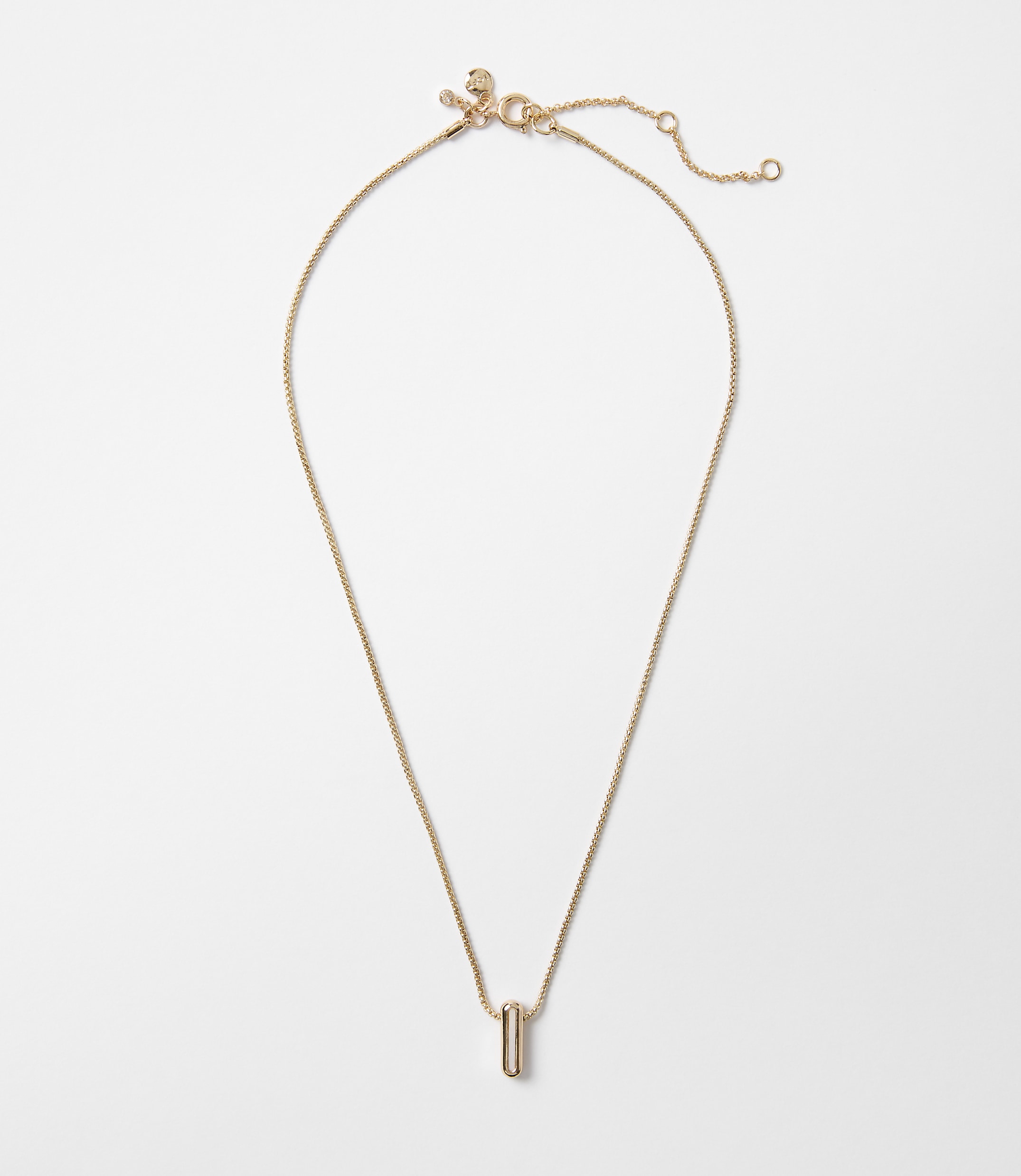 A delicate rose gold necklace with a minimalist bar pendant hangs against a plain white background.