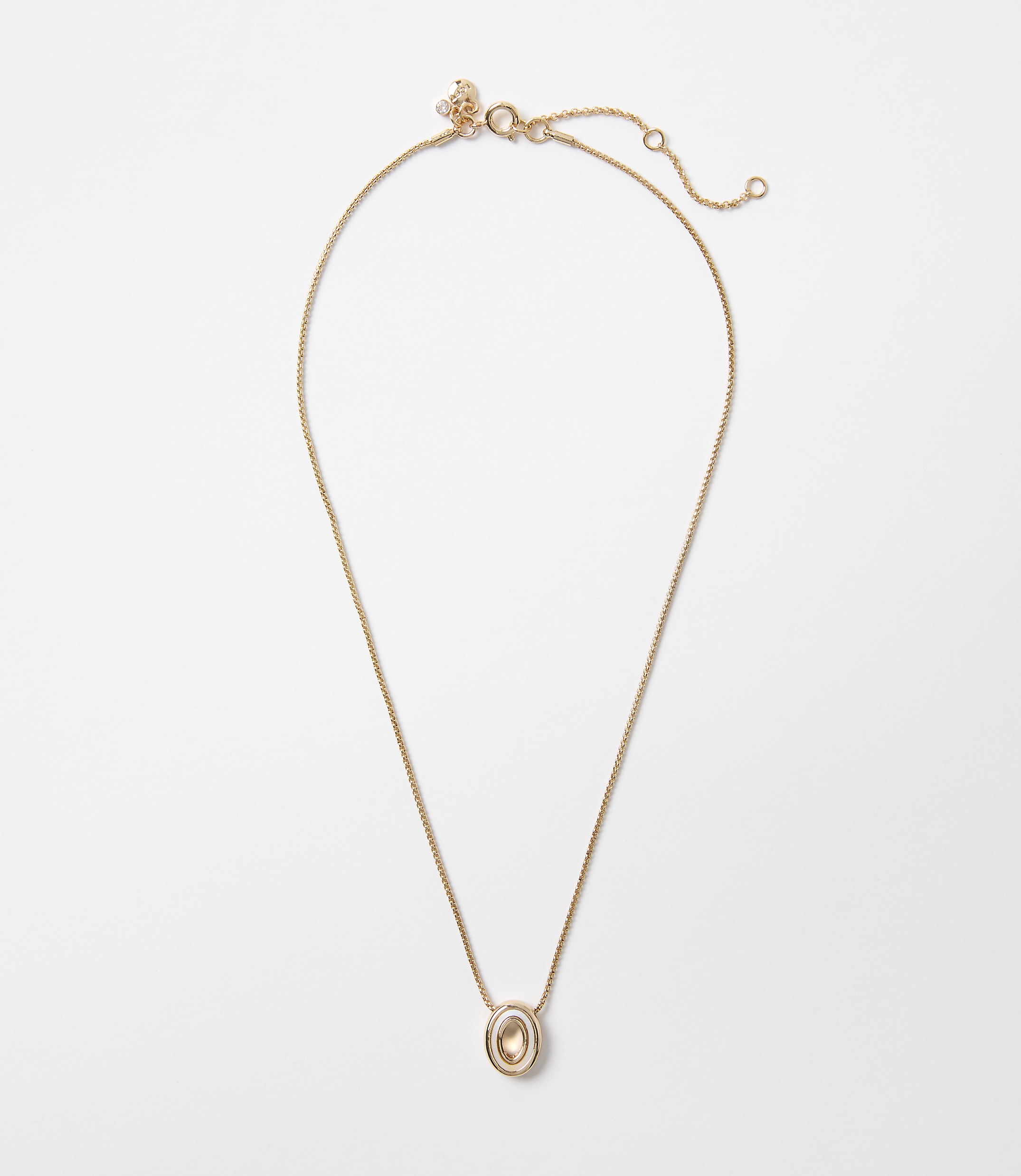 A delicate gold chain necklace with an oval, amber-colored pendant hangs against a plain white background.