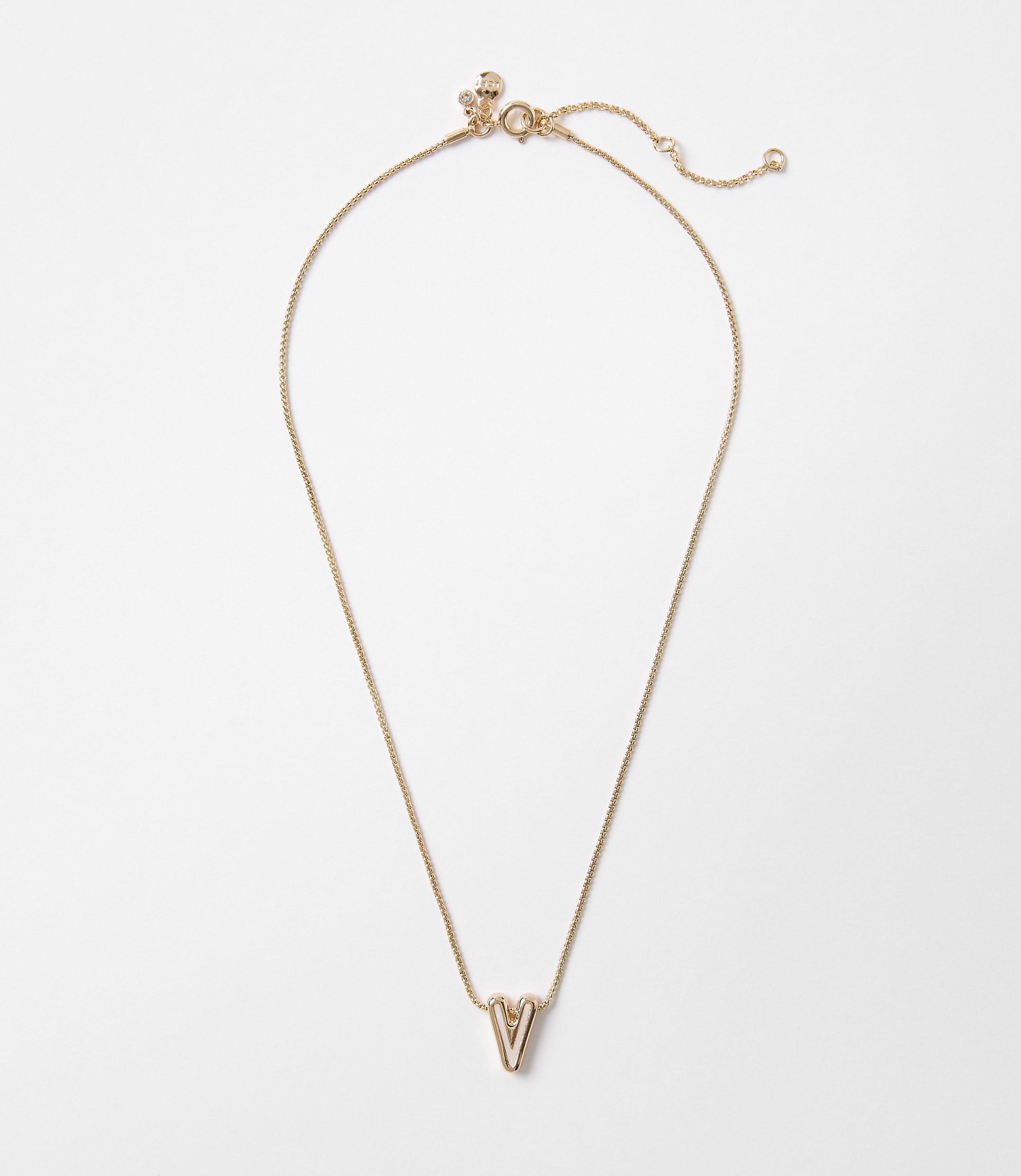 A delicate gold necklace with a "V" pendant hangs against a plain white background.
