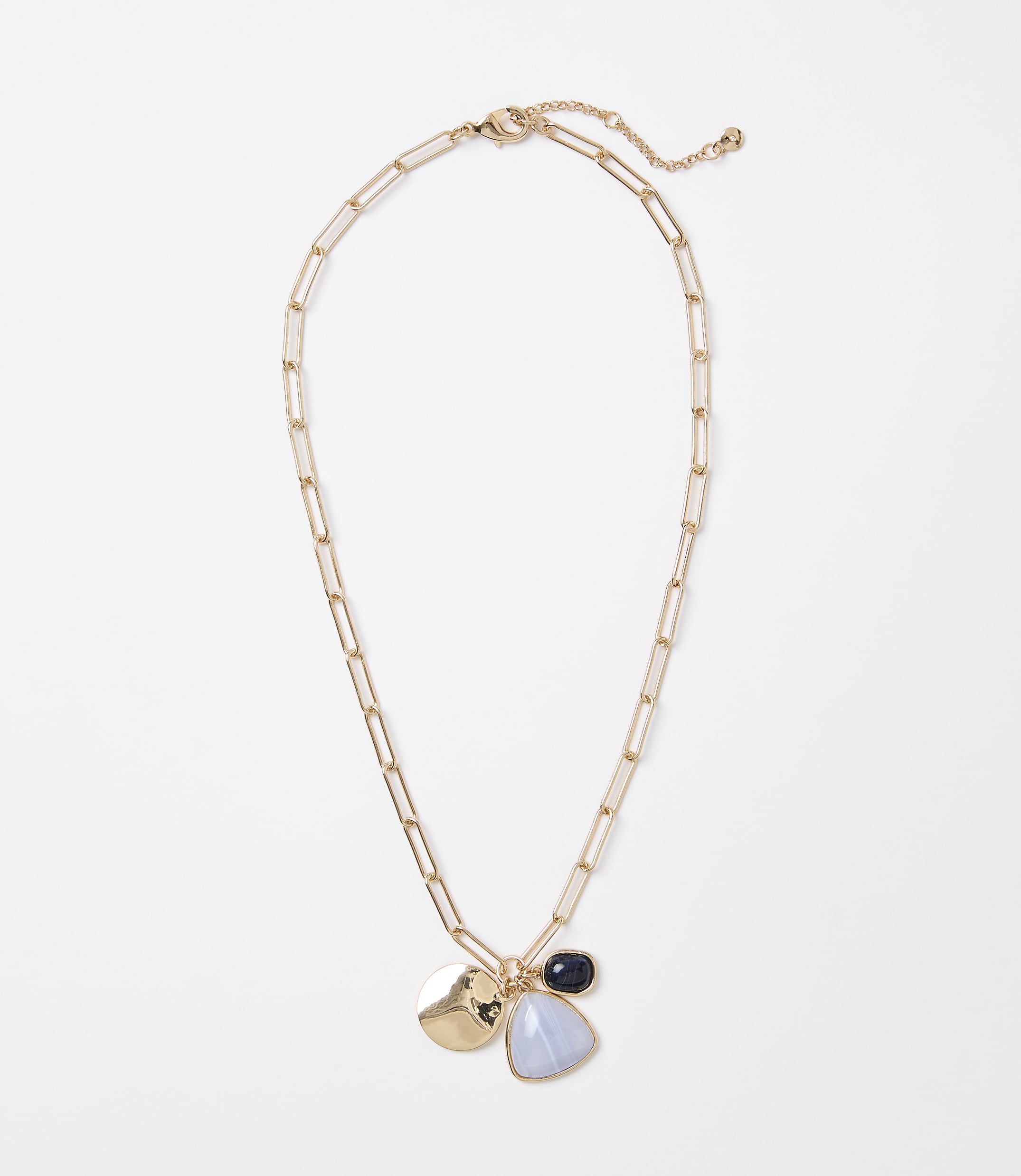 A gold chain necklace with three charms hangs against a plain white background.