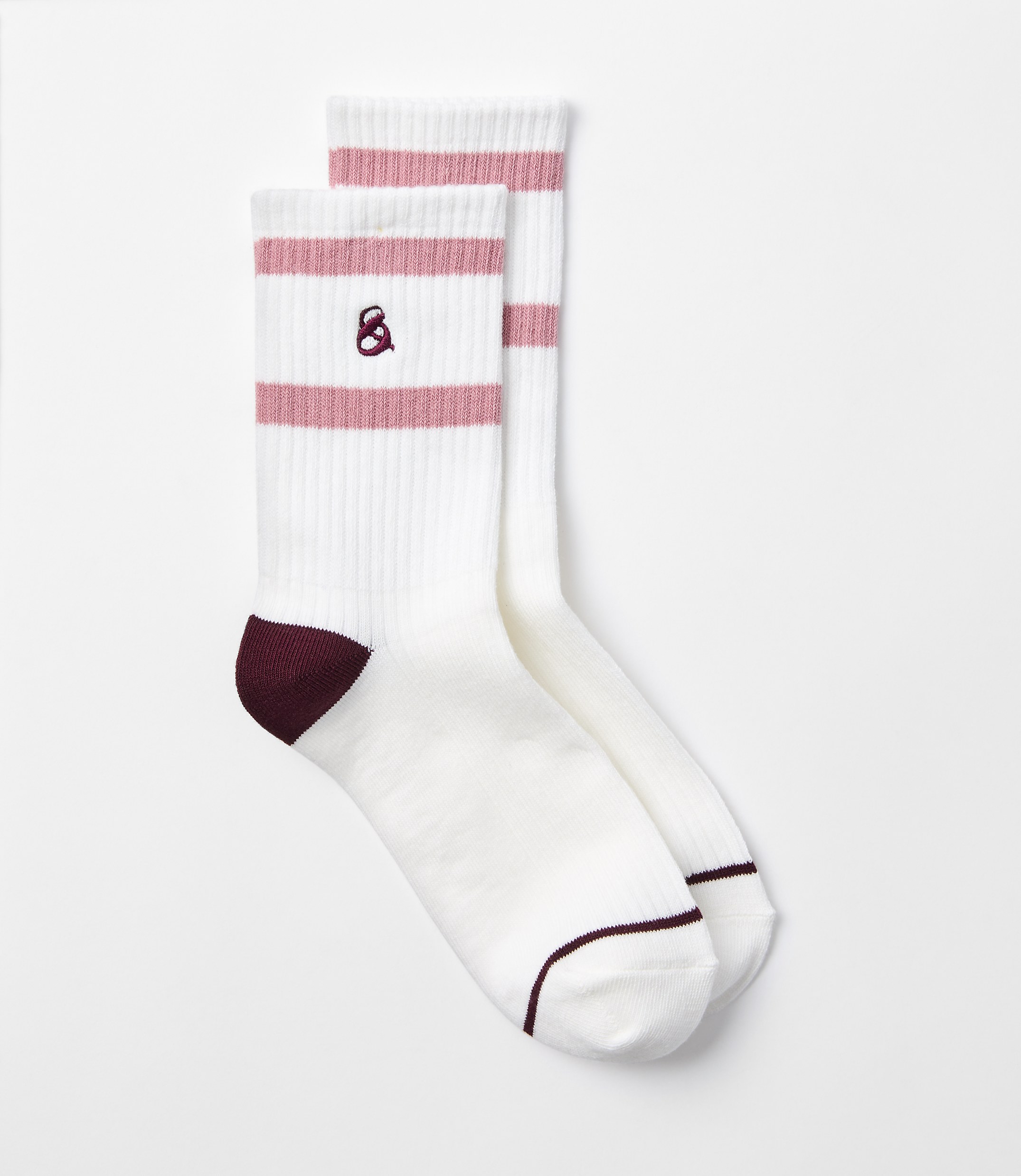 A pair of white crew socks with pink stripes and maroon heels are laid out against a plain white background.