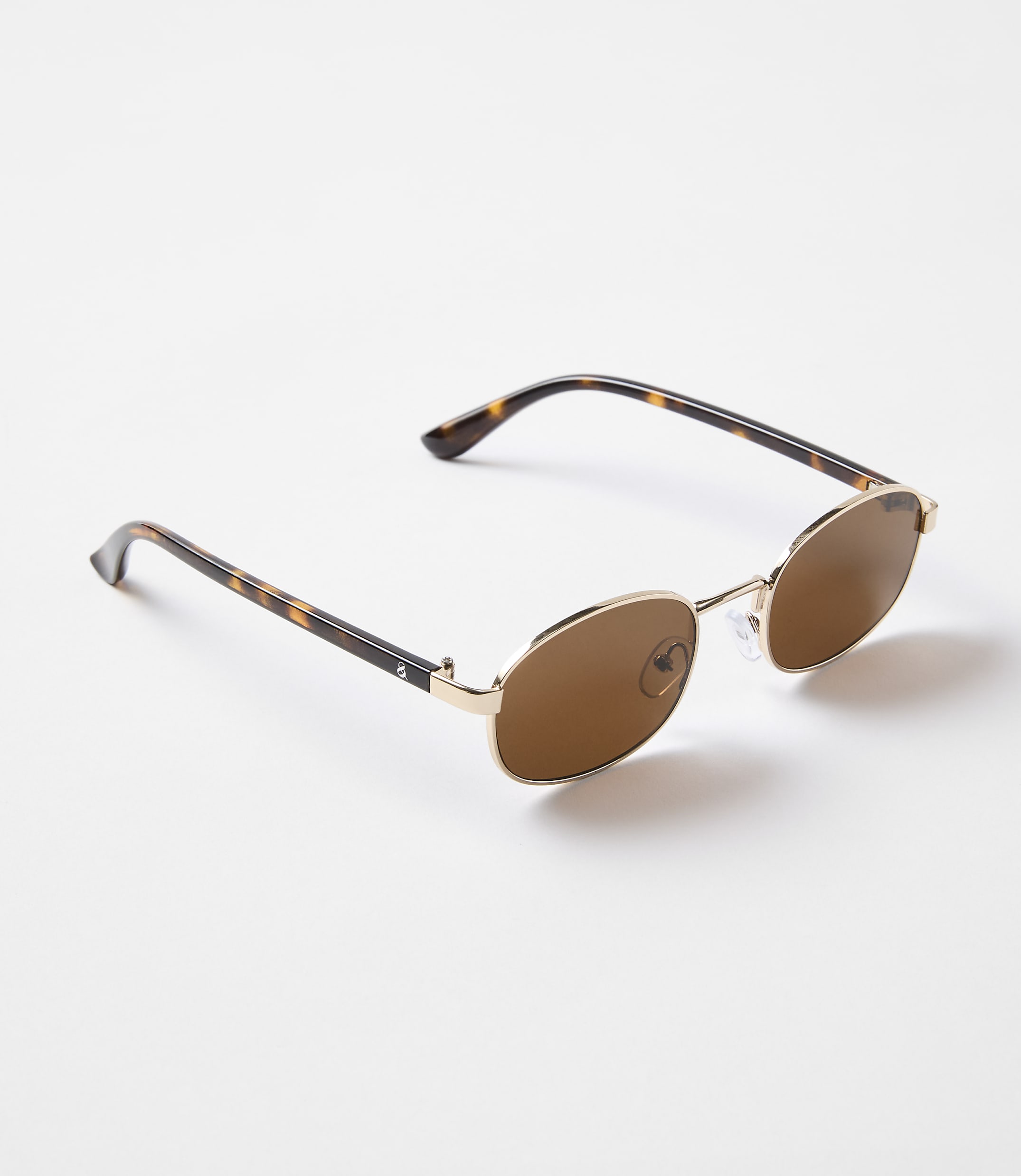Tortoiseshell-patterned sunglasses with gold frames rest on a plain white background.