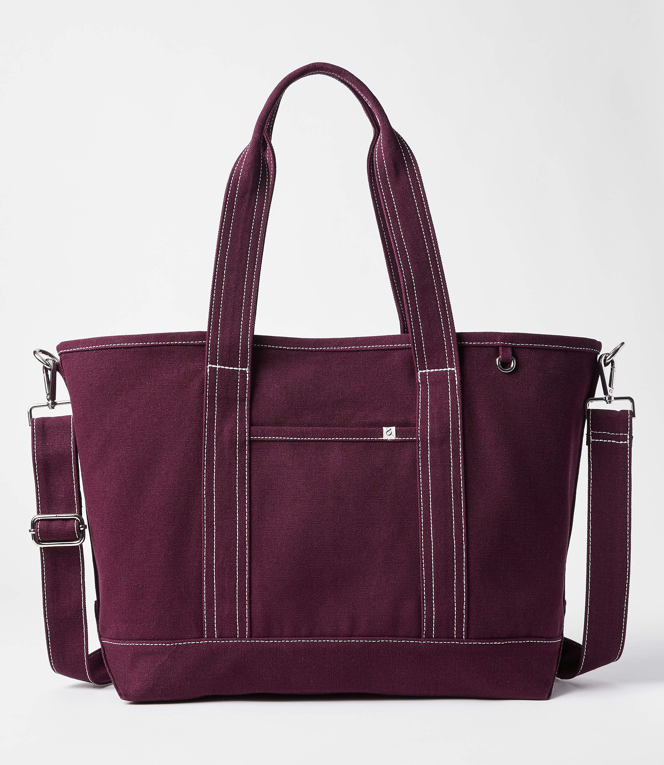 A maroon canvas tote bag with white stitching and a detachable shoulder strap sits against a plain white background.